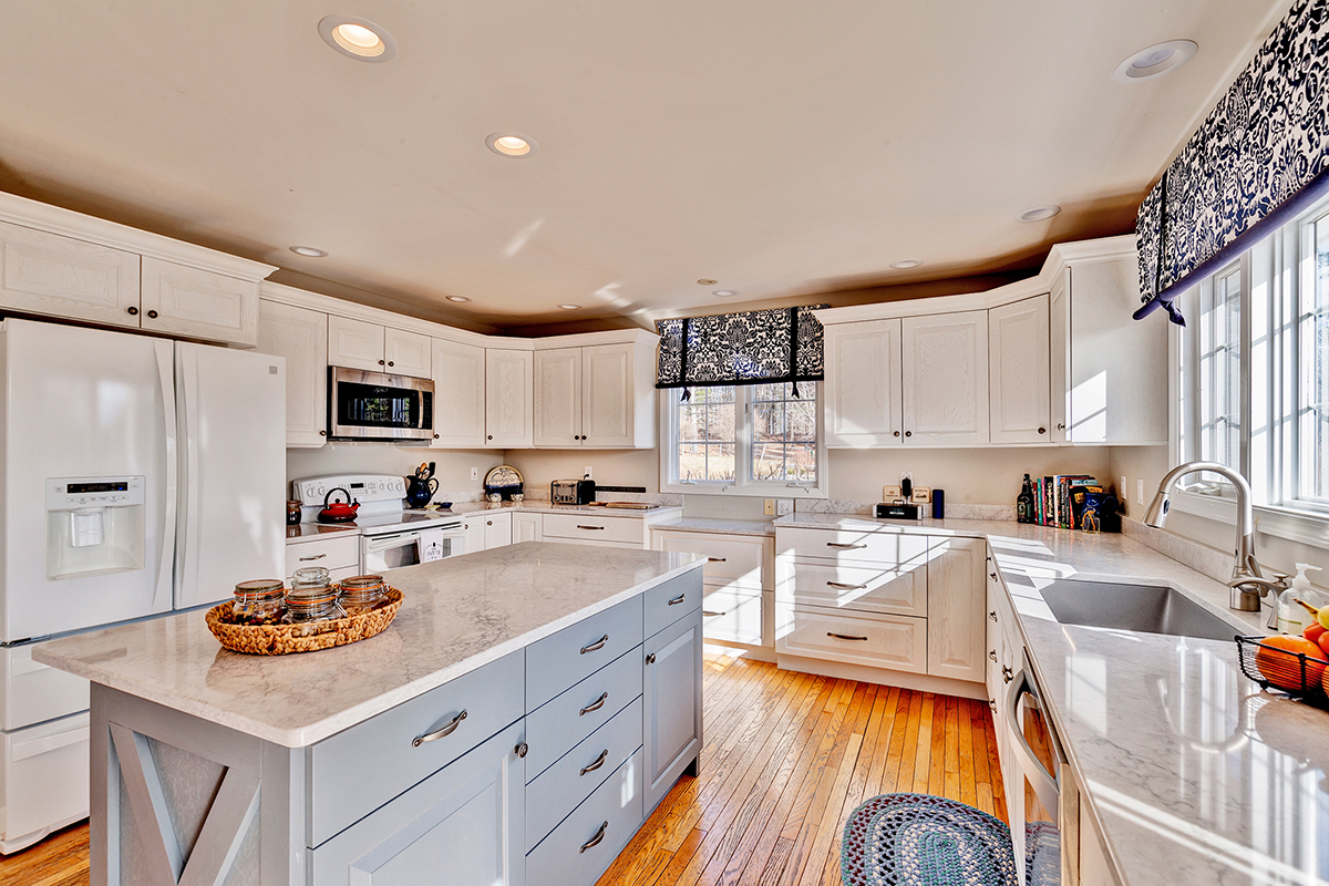 White kitchen cabinets with gray island