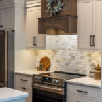 White kitchen cabinets with dark stained hood