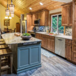 warm stained kitchen cabinets and green island