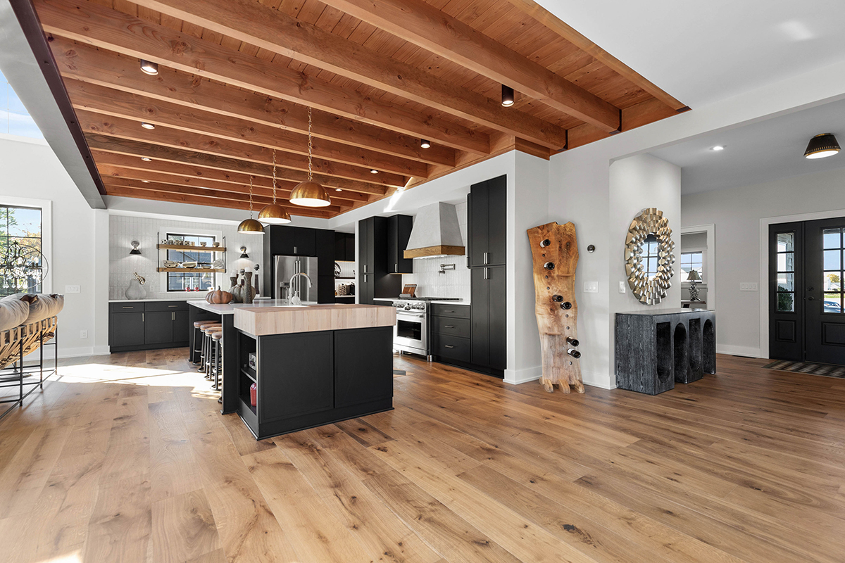 open kitchen and brown wooden floorplan, equipped with black cabinetry and modern appliances.