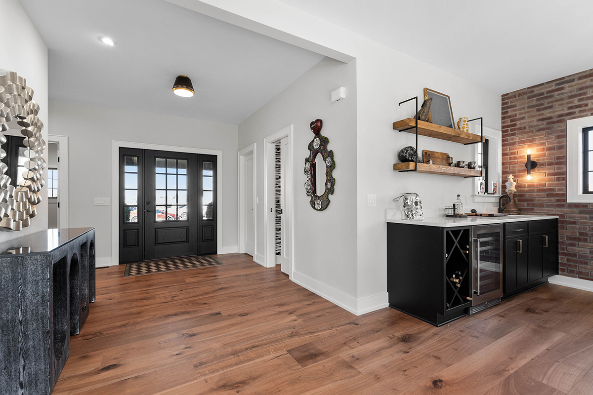 open entryway with black liquor cabinet