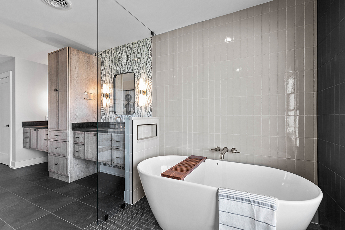 this angle of the bathroom shows the large tub along with the built in dual sinks, and the large linen cabinet.