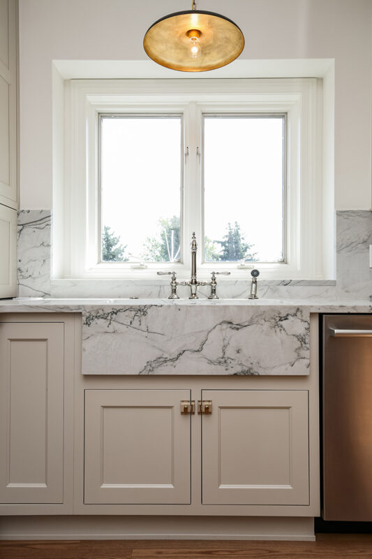 white wooden cabinetry with marbled stone countertops.