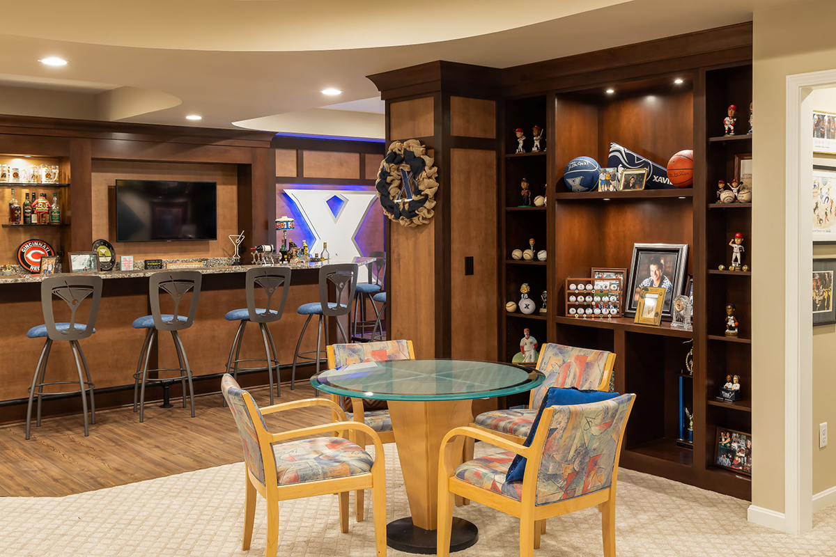 Shows the sports bar in the basement with a round table.