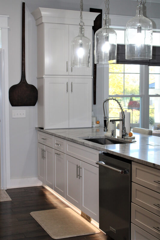 We see the dishwasher and the sink beside it. There is a under cabinet lighting that is featured in this photo.