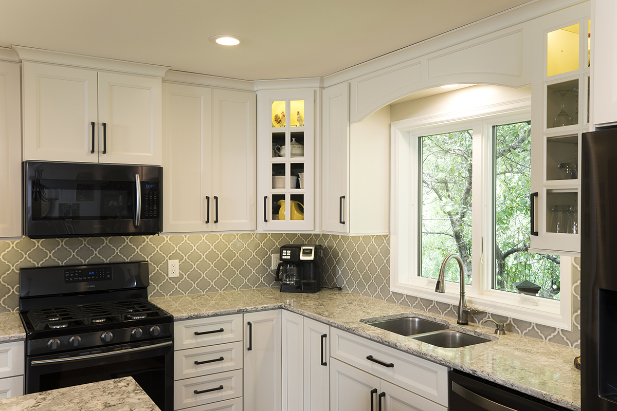 white kitchen cabinetry with black accents and stone countertop.