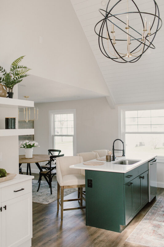 The island in this all white kitchen, the island is dark green.
