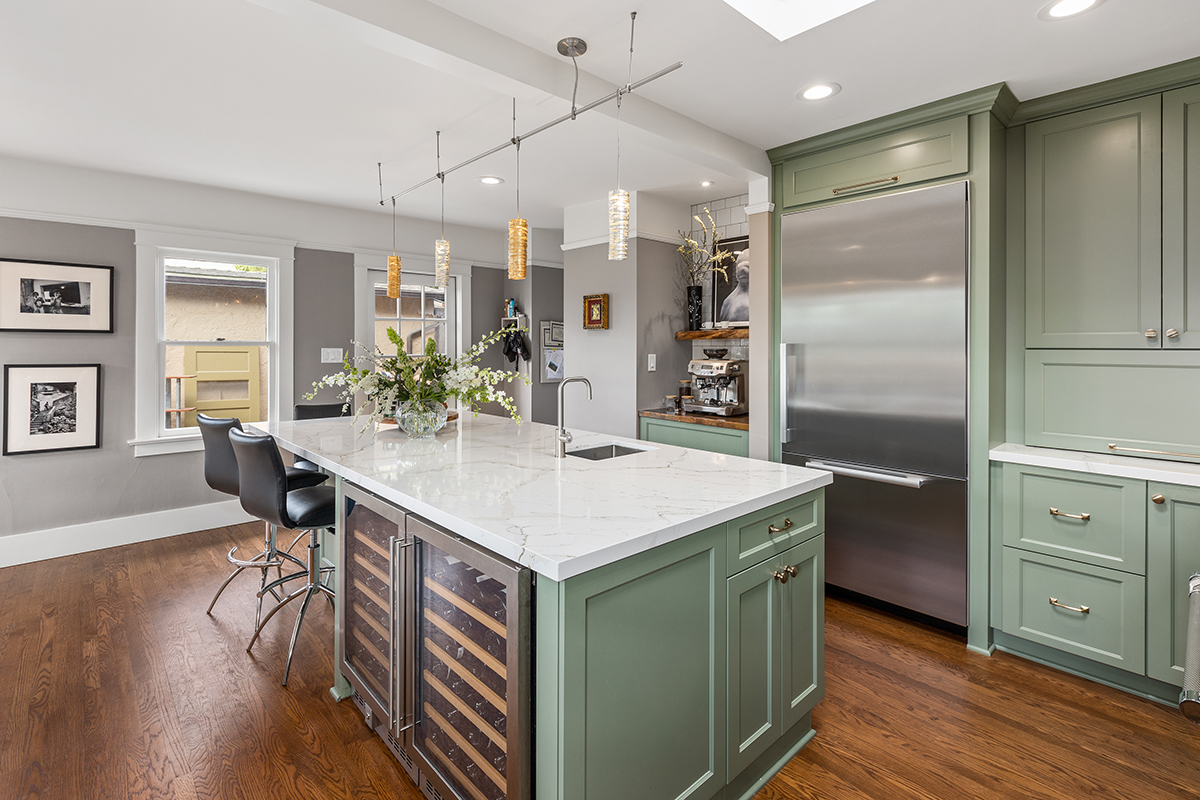 mint green kitchen cabinets with white countertops and silver appliances