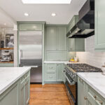 mint green kitchen with white countertops and large stovetop