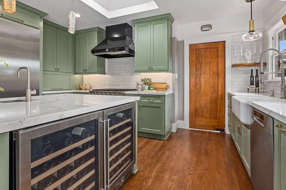 large brown mudroom door in a light green kitchen with double wine coolers