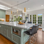 light green kitchen cabinets with white countertops and island