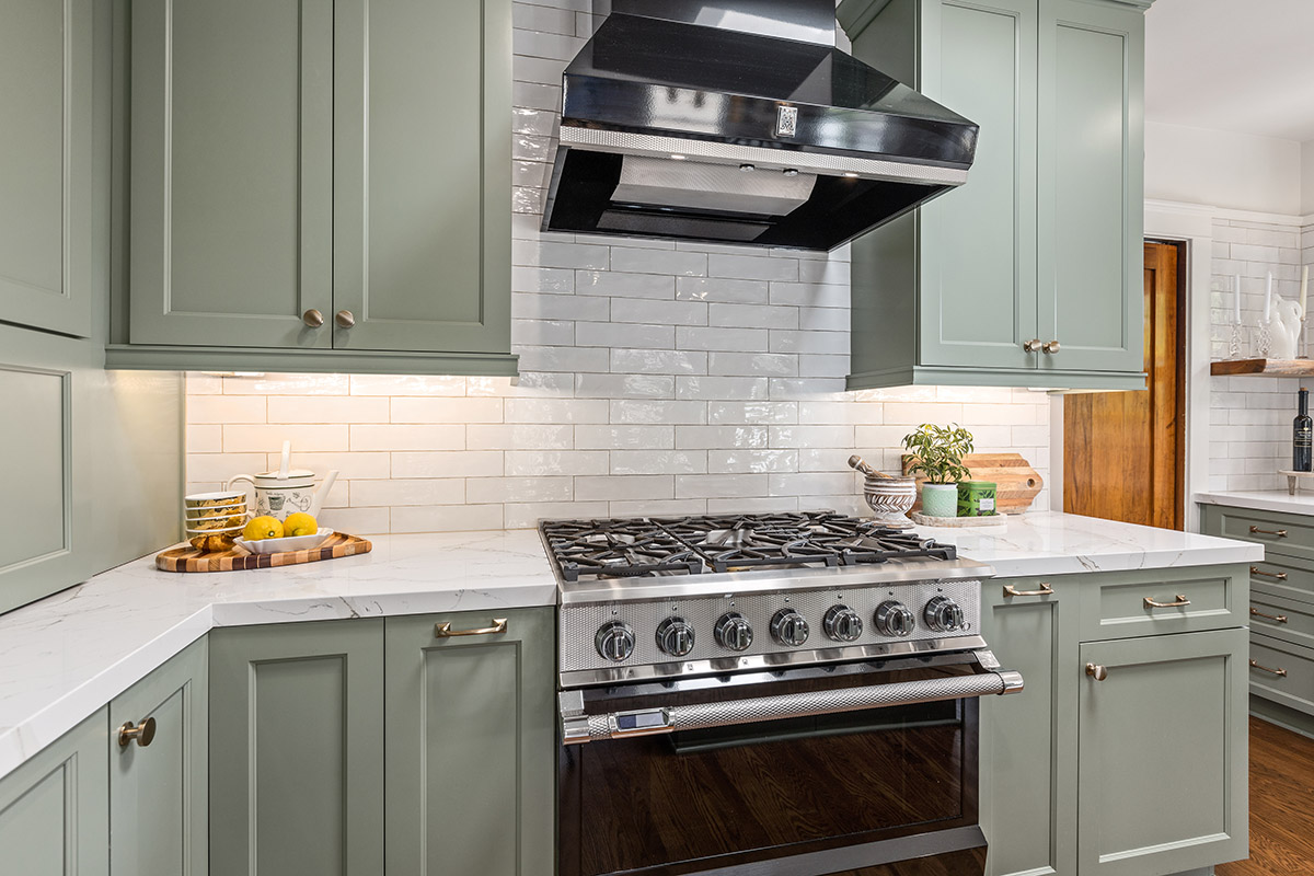 white brick backsplash in front of mint green kitchen cabinets