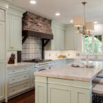 custom light green cabinets with gold hardware in kitchen with island