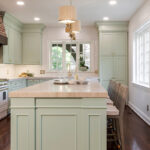 light green cabinets on kitchen island with gold hardware and brown accents.