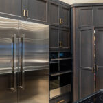 dark cabinets with gold hardware, silver appliances in kitchen