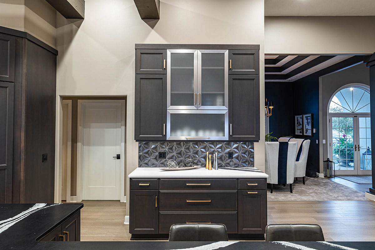 dark gray cabinets with silver appliances and gold hardware