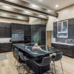 dark brown kitchen cabinets with gold hardware and shiny black island