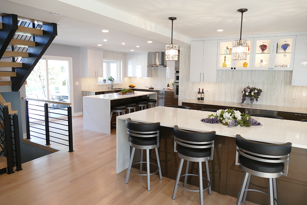 The morden kitchen has high-gloss, white acrylic cabinets on the top with brown, high-gloss acrylic cabinets on the lower half of the kitchen. The countertops are white.