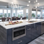 glossy acrylic kitchen cabinets sit under a white stone countertop on the island. Open floorplan kitchen with many large windows.