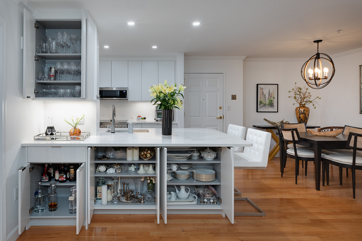 modern white kitchen cabinetry and bar setup with bright wooden flooring. floorplan opens to dining table.