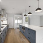 white and blue modern kitchen cabinetry setup with bright lighting and open space.