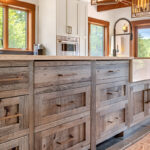 grainy wood island cabinetry with large white inset sink.