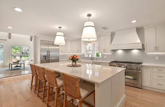 All white kitchen with wooden accent. Bright modern appliances.
