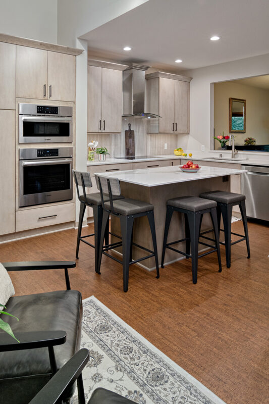 a light natural colored kitchen that shows the black accented chairs.