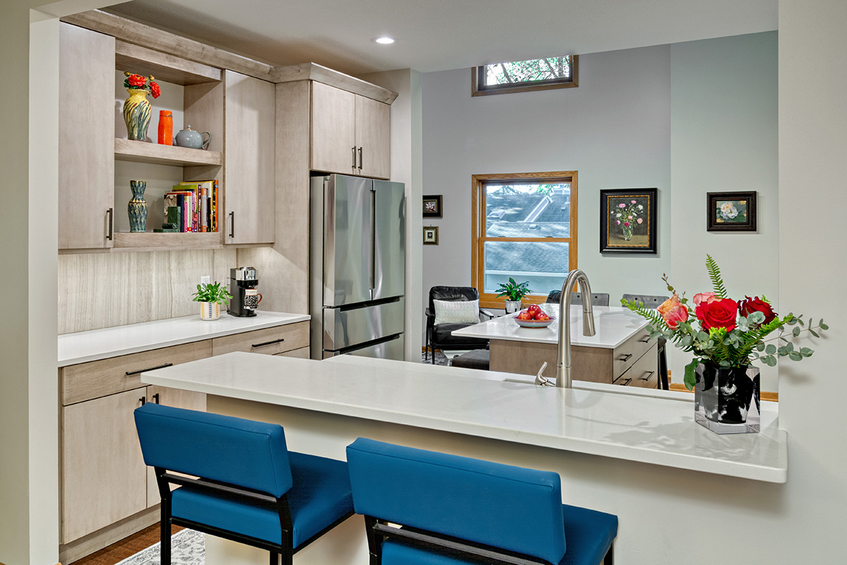 natural colored kitchen with white cabinets and blue island chairs.