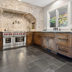A kitchen with stone counter tops and a stove
