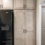 smooth wooden pantry doors with black finishes on the handles.