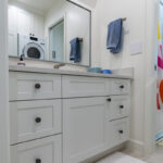white bathroom vanity and washer dryer setup