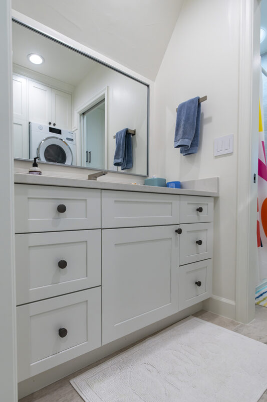white bathroom vanity and washer dryer setup