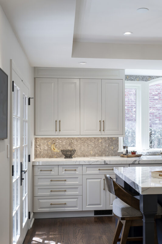 white kitchen cabinetry with stone vanity, gold accents and dark hardwood flooring
