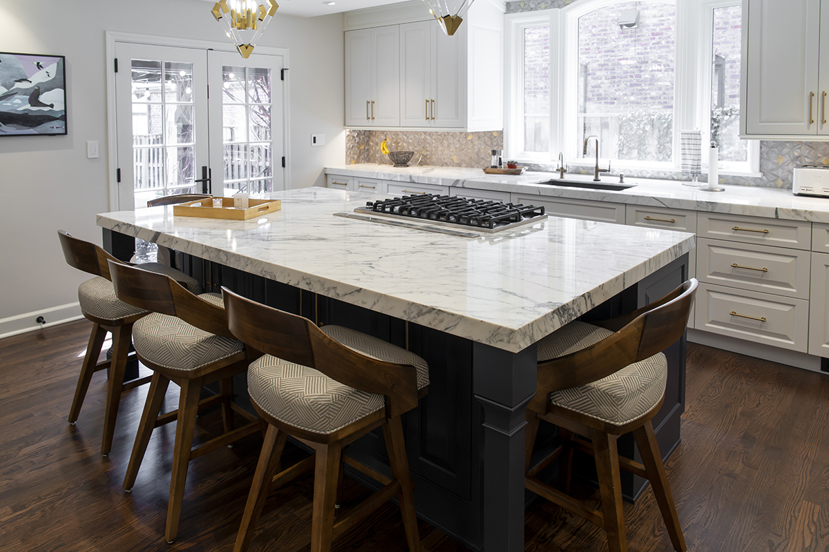 white kitchen cabinets with a large stone island dining setup