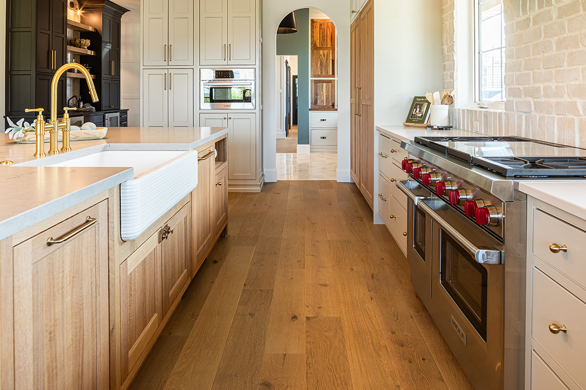 Country style kitchen with white, black, and brown wooden cabinetry. Gold and red accents throughout.