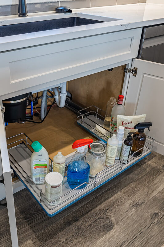 kitchen sink drawer filled with cleaning supplies