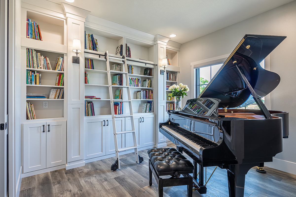 library and piano room with white cabinetry