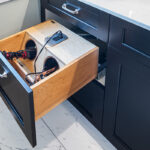 black bathroom cabinetry with curling iron and hair dryer specific drawer