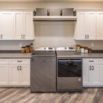 laundry room with white cabinets surrounding a washer & dryer pair