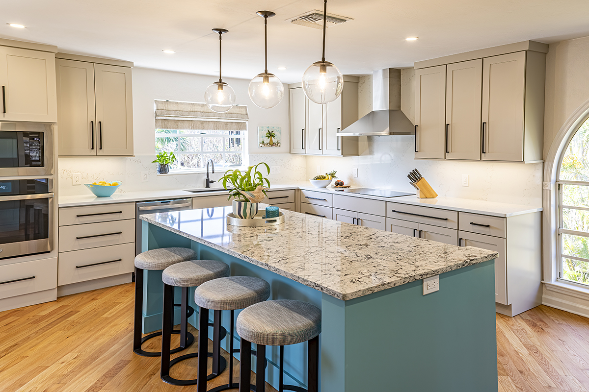 A dual tone kitchen with a teal blue island and neutral cabinets.