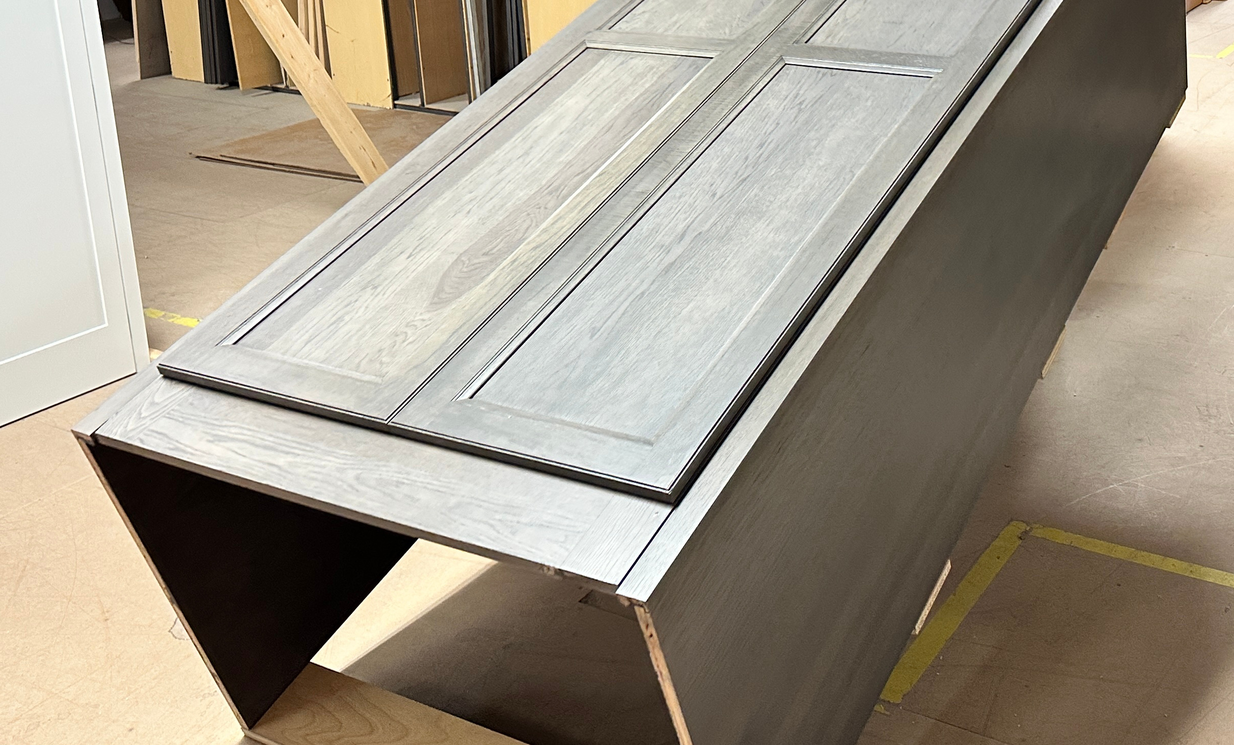 close up view of a gray wooden pantry cabinet. The cabinet is angled upright.
