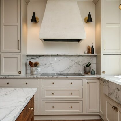 white kitchen with marble counter tops, black and gold accents in the hardware and light fixtures.