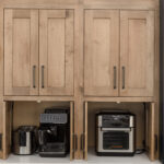 Stained kitchen cabinets with open pocket doors revealing appliances