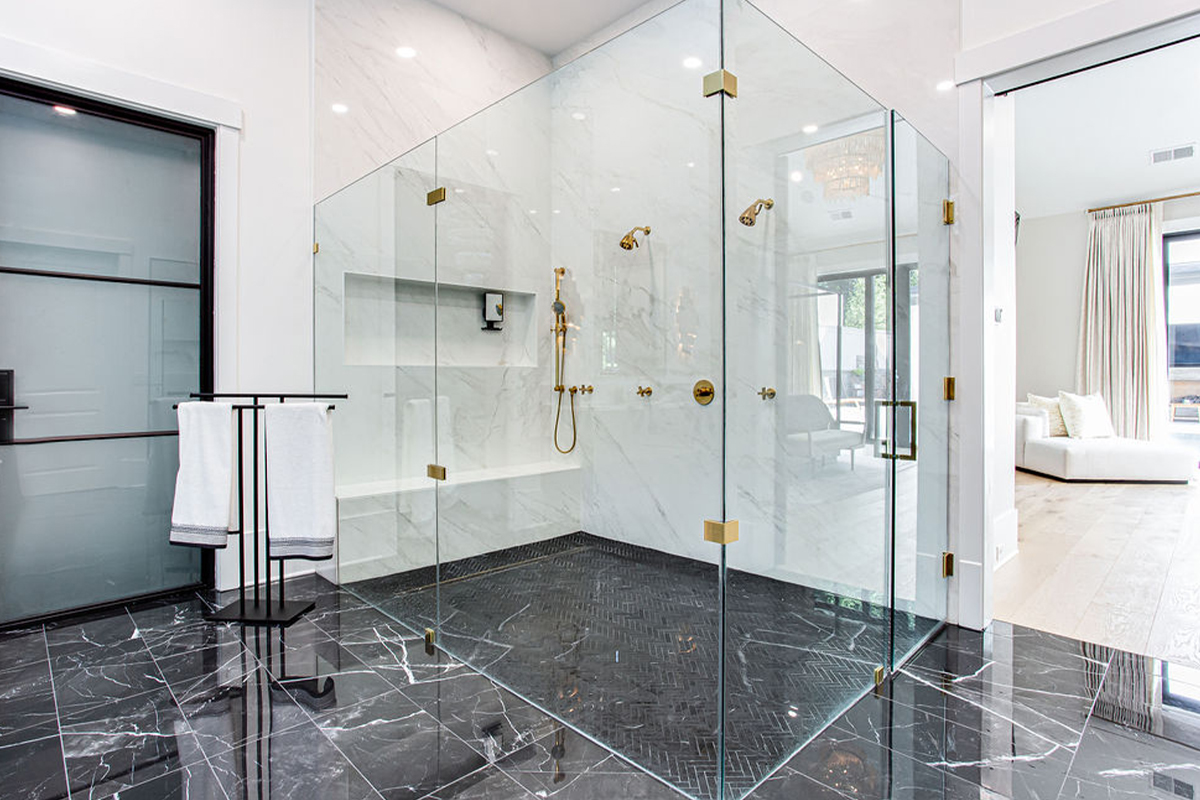 Large open glass shower looking into the master bedroom with reading area.