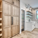 Stained and painted kitchen cabinets featuring paneled refrigerator doors