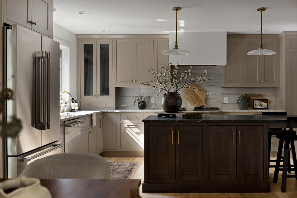 Light painted kitchen perimeter cabinets with stained island