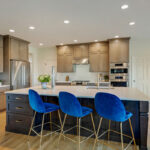 Stained kitchen and island cabinets with blue island chairs