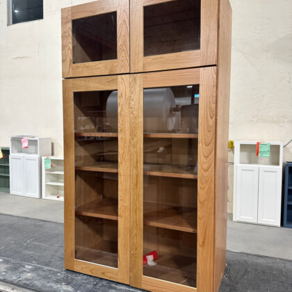 Stained stacked wall cabinet with glass door inserts.