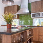 Kitchen with stained cabinets and tile backsplash under the range hood.